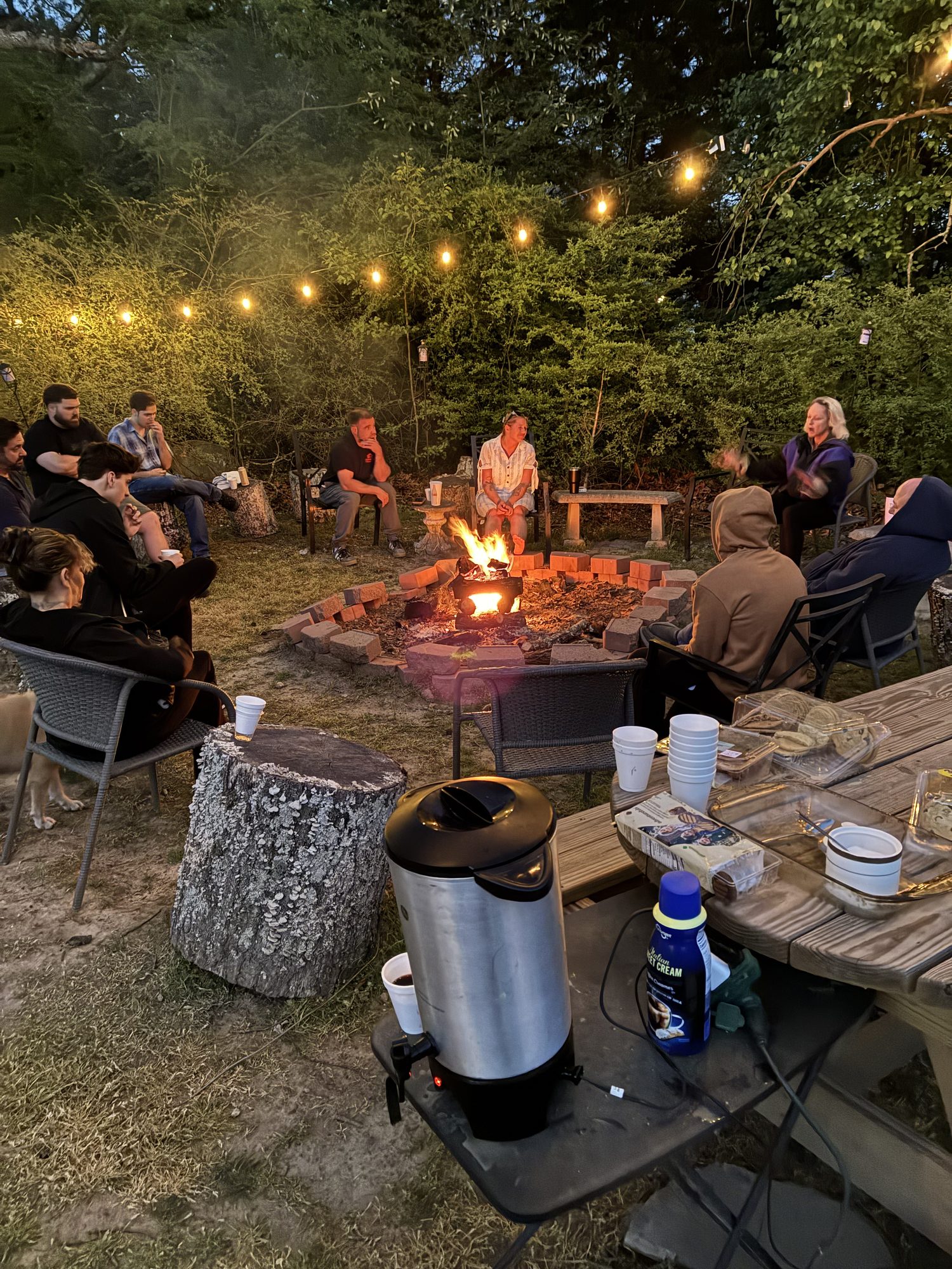 Residents gathered around the backyard fire pit at Heart's Recovery Residence